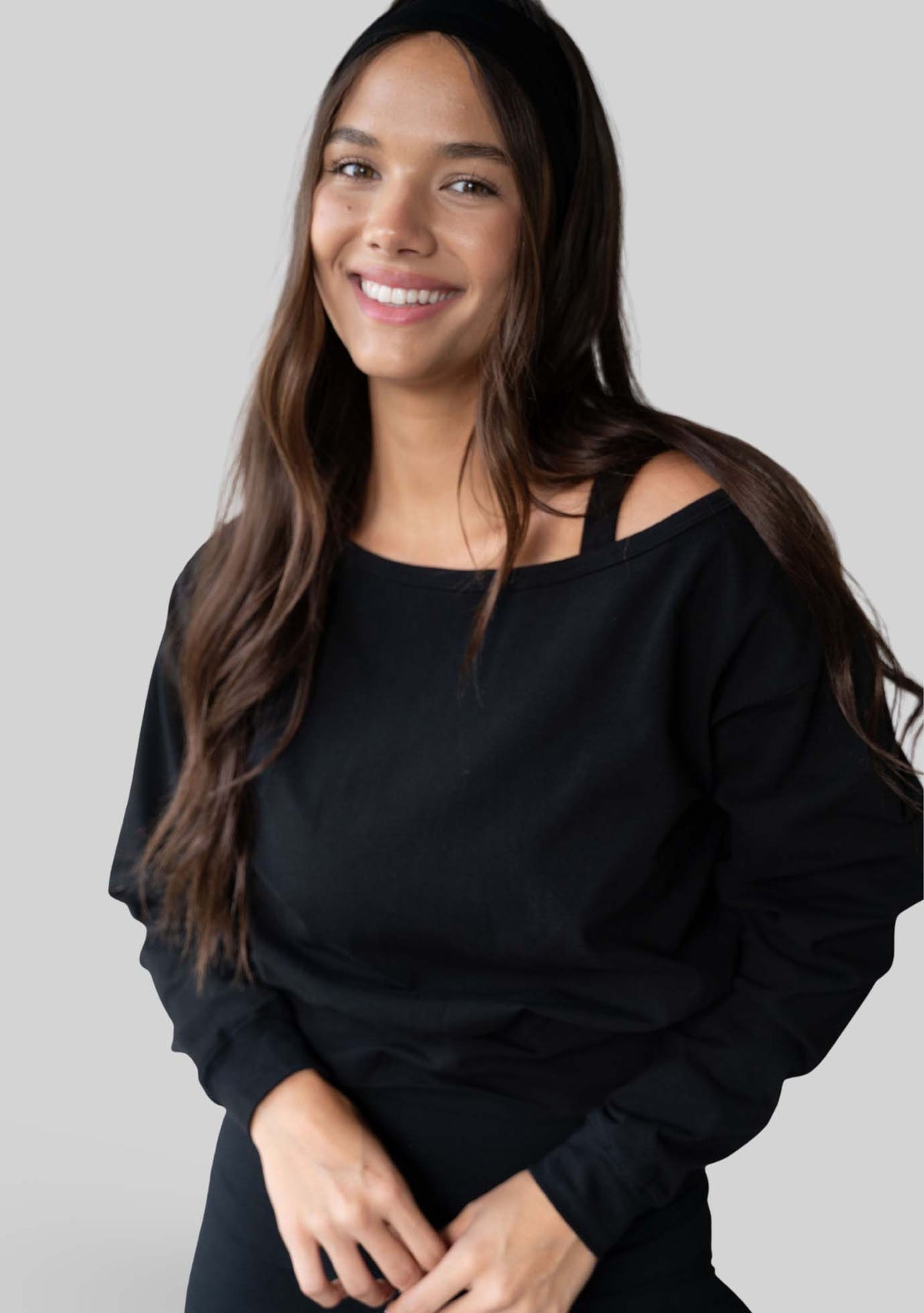 Model wearing the JALA Aela Top in Black, styled off the shoulder, front view