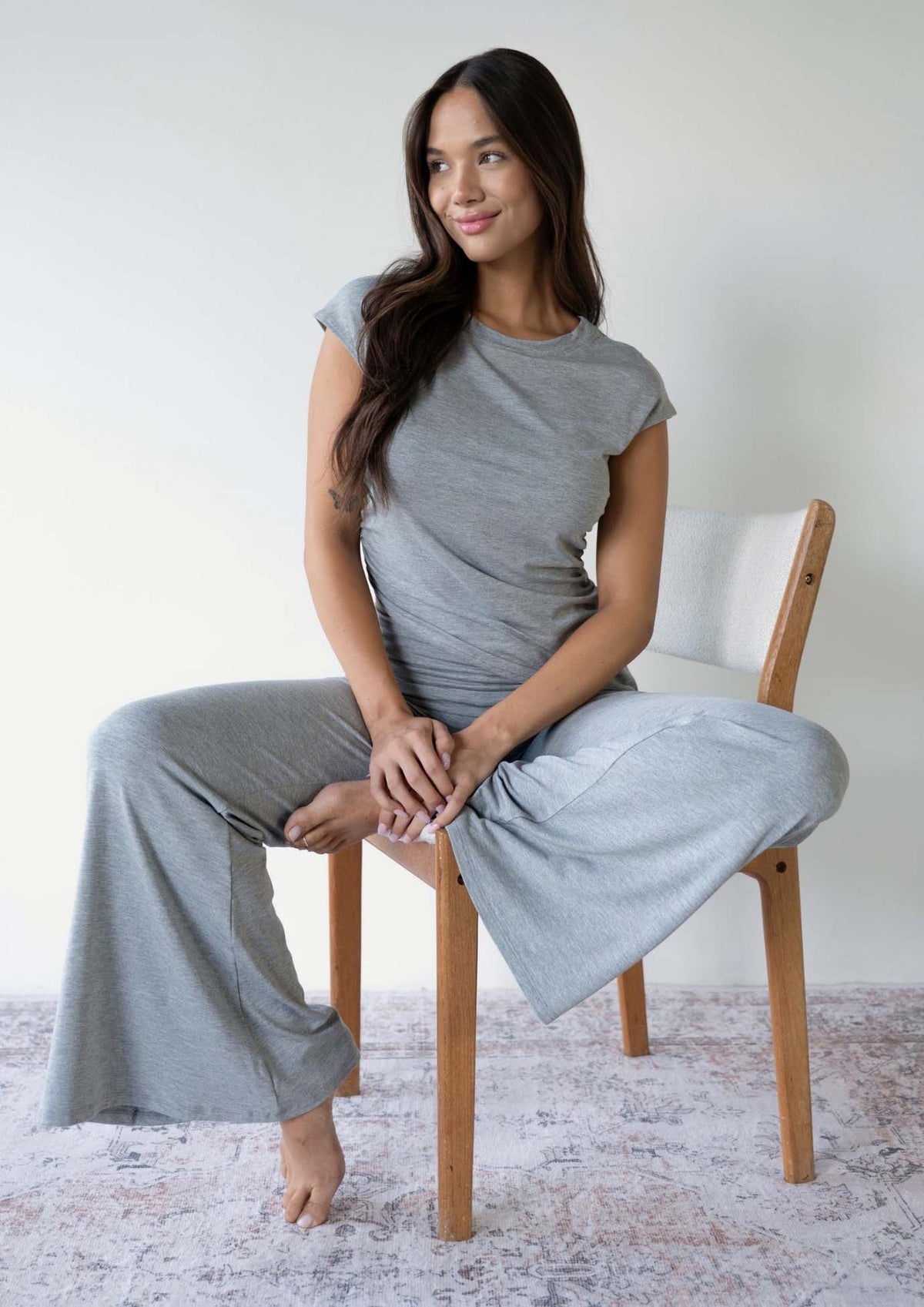 Model wearing the JALA Chill Yoga Pant in Heather Grey with roll down waist and wide leg, lifestyle shot