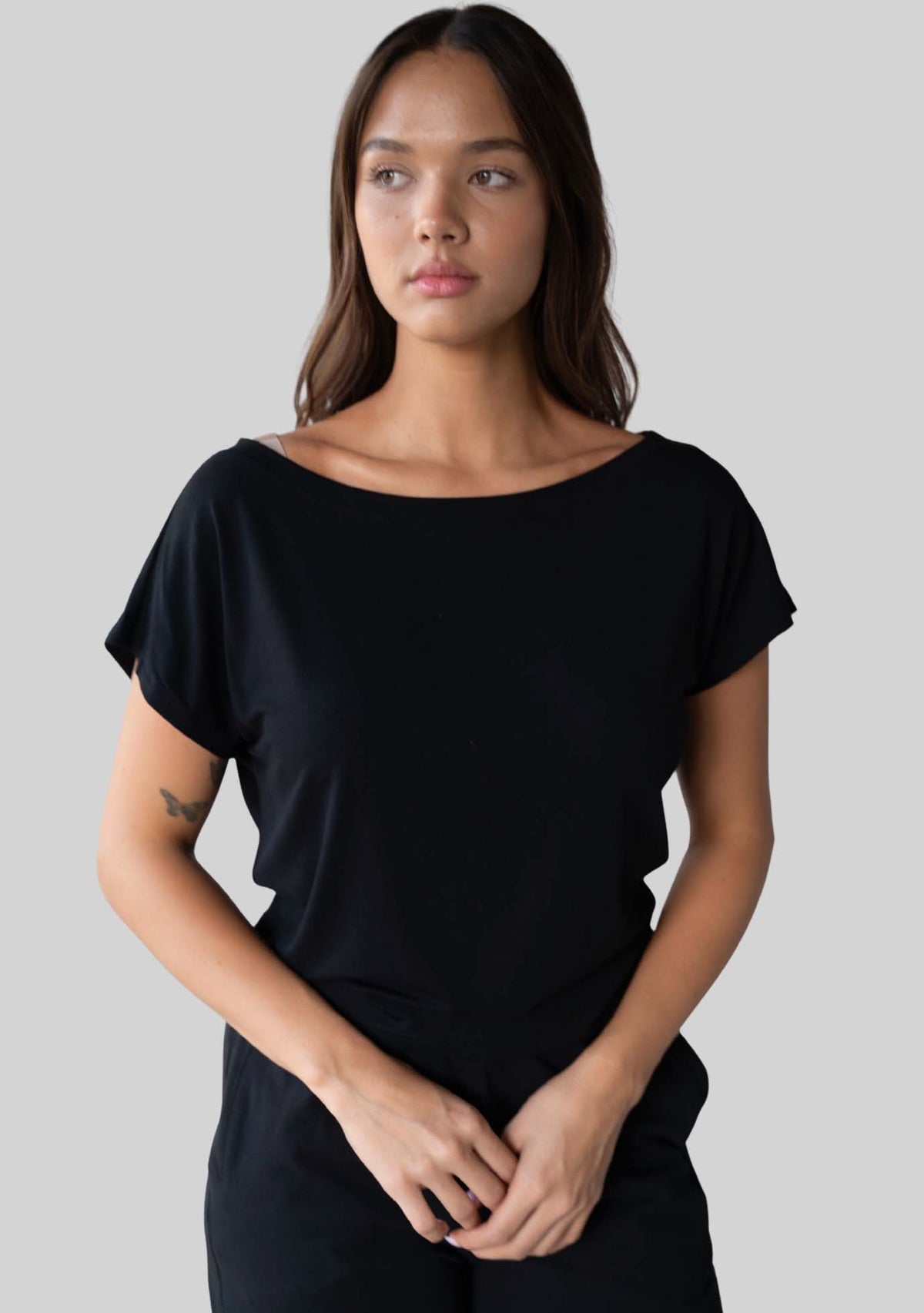 Model wearing the JALA Dreamer Dolman Tee in Black with soft dolman sleeves, front view