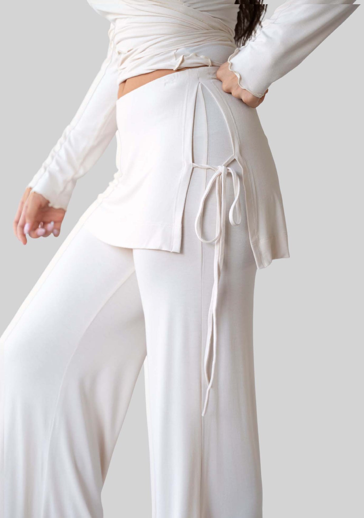 Side view of the JALA Luna Pant in Cream showing the skirt overlay and side ties