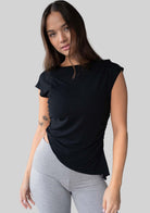 Model wearing the JALA Align Tee in Black with side shirring and an asymmetrical hem, front view