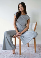 Model wearing the JALA Chill Yoga Pant in Heather Grey with roll down waist and wide leg, lifestyle shot