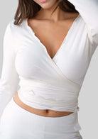 Model wearing the JALA Kira Wrap Top in Cream, styled front view