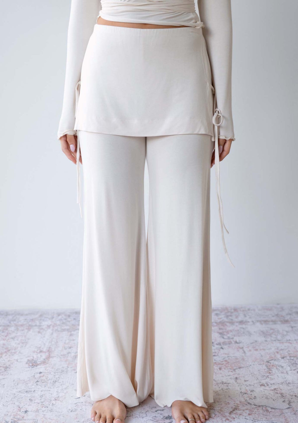 Model wearing the JALA Luna Pant in Cream with low rise waistband and flowy fit, front view