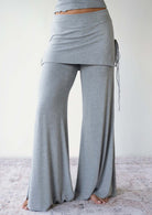 Model wearing the JALA Luna Pant in Heather Grey with skirt overlay and side ties, front view